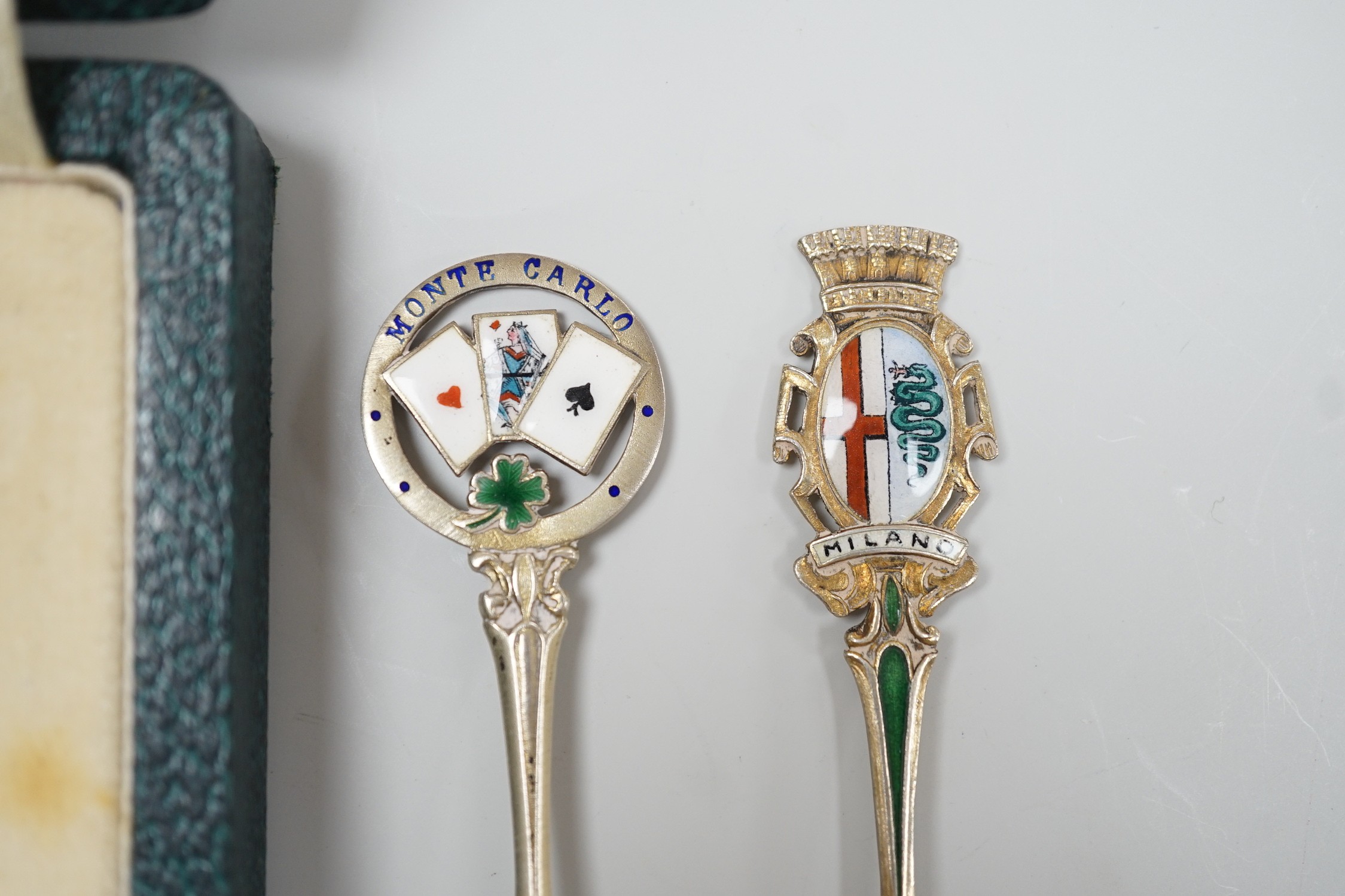 A cased set of six George V silver and polychrome enamel coffee spoons, Barker Bros. Silver Ltd, Birmingham, 1933 and two similar souvenir spoons.